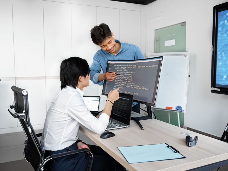 Hai người cùng xem đoạn code trên màn hình
